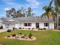 Inviting single-story home with lush front lawn and lovely landscaping details at 27003 Racquet Cir, Leesburg, FL 34748