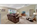 Cozy living room with plush seating, ceiling fan, and natural light at 27003 Racquet Cir, Leesburg, FL 34748