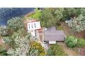 Aerial view of home with metal roof, detached garage, and extra shed building, all surrounded by trees at 31241 Benton Dr, Eustis, FL 32736