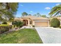 Charming one-story home with a manicured lawn, palm trees, and a two-car garage at 3163 Southern Trce, The Villages, FL 32162