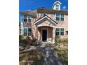 Tan townhouse featuring a covered front porch, updated windows and professional landscaping at 3417 Westchester Square Blvd # 204, Orlando, FL 32835