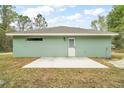 Rear exterior of the house, featuring a patio and access door at 35 Sequoia Loop Ct, Ocklawaha, FL 32179