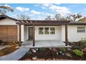 Inviting front porch featuring a pergola, updated landscaping, and a stylish front door at 4614 Eagles Nest Rd, Fruitland Park, FL 34731