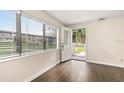 Bright entryway featuring hardwood floors, a window with blinds, and a partially open front door at 580 Page Ln, Mount Dora, FL 32757