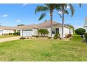 Well maintained home with a two car garage and green lawn at 589 Sherwood St, The Villages, FL 32162