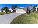 Wide concrete driveway leading up to a two-car garage with lush green grass surrounding the home at 5952 Brittania Blvd, Tavares, FL 32778