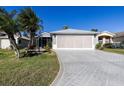 A well-maintained home featuring a paved driveway, two-car garage, and screened-in porch at 5952 Brittania Blvd, Tavares, FL 32778