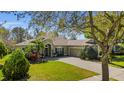 Beautiful single-story home with a well-maintained lawn and mature trees at 6240 Tremayne Dr, Mount Dora, FL 32757