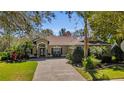 Charming single-story home featuring a brick driveway and manicured landscaping at 6240 Tremayne Dr, Mount Dora, FL 32757