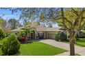 Beautiful single-story home with a well-maintained lawn and mature trees at 6240 Tremayne Dr, Mount Dora, FL 32757