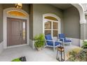 Covered front porch with seating and views of the landscaped yard at 674 Waterman Way, The Villages, FL 32163