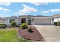 Well-maintained single-story home featuring manicured lawn, elegant landscaping, and a two-car garage, providing curb appeal at 686 Aberdeen Run, The Villages, FL 32162