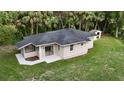Charming home featuring a new roof and landscaping, with large windows and a sliding glass door to a patio at 709 S Highland St, Mount Dora, FL 32757