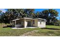 Rear exterior showcasing the home's design, outdoor space, and natural surroundings with new concrete patio at 709 S Highland St, Mount Dora, FL 32757