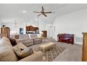 Bright living room with neutral decor, high ceilings, and a ceiling fan at 9750 Pepper Tree Pl, Wildwood, FL 34785