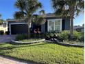 Charming home with mature landscaping, a paver driveway, dark gray trim and a two-car garage at 10267 Julia Isles Ave, Oxford, FL 34484