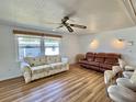 Bright living room featuring wood floors, comfortable sofas, and ample natural light at 104 Chestnut St, Leesburg, FL 34748