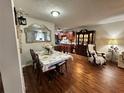Elegant dining room featuring wood floors, and open view to the kitchen and bright living space at 12237 Tavares Ridge Cir # 67, Tavares, FL 32778