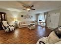 Bright and airy living room with wood flooring, ceiling fan, large couch and a decorative working space at 12237 Tavares Ridge Cir # 67, Tavares, FL 32778