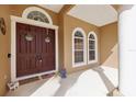 Inviting front entrance with double doors, arched windows, and a covered porch area. Welcome home! at 13101 Biscayne Dr, Grand Island, FL 32735