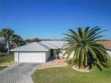 An aerial shot showcases a well-maintained home with a neatly paved driveway, lush lawn, and a striking palm tree at 17490 Se 110Th Ter, Summerfield, FL 34491