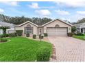 Well-maintained home featuring manicured landscaping, a brick driveway, and a welcoming facade at 17728 Se 115Th Ct, Summerfield, FL 34491