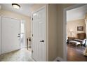 Bright foyer with tile flooring, white door, and view into a beautifully staged bedroom at 1945 Maple Cir # 45E, Tavares, FL 32778