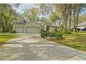A large driveway leads to a well-maintained home with a spacious three-car garage at 19666 Sw 88Th Loop, Dunnellon, FL 34432