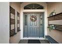 Charming entryway with a decorated front door, shelving, and a comfortable bench at 2212 Bachman Path, The Villages, FL 32162