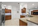 Spacious kitchen featuring granite countertops, tile floors, and ample cabinetry at 2212 Bachman Path, The Villages, FL 32162