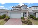 Beautiful two-story home showcasing a brick driveway and modern architectural details at 2289 Mystic Maze Ln, Minneola, FL 34715