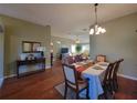 Well-lit dining room with hardwood floors, seating for six, and seamlessly connected to the living room at 2304 Jonesbury Run, The Villages, FL 32162