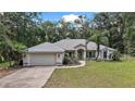 Charming single-story home featuring a well-manicured lawn, attached two-car garage, and a welcoming front porch at 2541 Lake Griffin Rd, Lady Lake, FL 32159