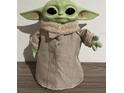 A toy figure of Grogu, also known as Baby Yoda, with green skin and big eyes, dressed in beige clothing at 255 Blueberry Ln, Davenport, FL 33837