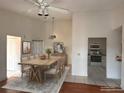 Bright dining room featuring a wooden table, tile flooring, and an open view of the kitchen with white appliances at 2562 Lakeway Branch Way # 3002, Orlando, FL 32839