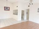 Spacious living room with tile and hardwood flooring, neutral paint, and view into the white kitchen at 2562 Lakeway Branch Way # 3002, Orlando, FL 32839
