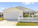 Single-story home featuring a well-kept lawn, driveway, and attached garage at 2606 Olivarez Way, The Villages, FL 32162