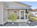 Inviting screened front porch features ample seating space and charming decor at 2606 Olivarez Way, The Villages, FL 32162