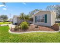 Landscaped front yard with green lawn, mulch beds, and charming exterior details at 2738 Privada Dr, The Villages, FL 32162