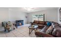 Bright living room features a modern tile flooring, leather sofa, and decorative fireplace at 3011 George Mason Ave # 3, Winter Park, FL 32792