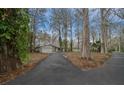Long driveway leading to the single-story home with an attached garage and mature trees at 30713 George Dr, Tavares, FL 32778