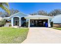 Home exterior showing a two-car garage filled with equipment and tools at 5241 Indian Ocean Loop, Tavares, FL 32778