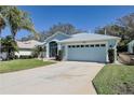 Well-maintained single-story home with blue exterior, two-car garage, and concrete driveway at 5241 Indian Ocean Loop, Tavares, FL 32778