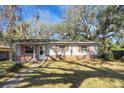 Well-maintained single-story home with red brick accents and lush lawn at 6213 Highland Ave, Leesburg, FL 34748