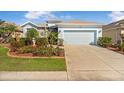 Charming single Gathering home featuring beautiful landscaping, stone accents and a two car garage at 8780 Bridgeport Bay Cir, Mount Dora, FL 32757