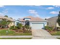 Single Gathering home boasting vibrant landscaping, stone accents, and a spacious two car garage at 8780 Bridgeport Bay Cir, Mount Dora, FL 32757