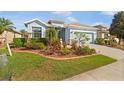 Single Gathering home boasting vibrant landscaping and a spacious two car garage at 8780 Bridgeport Bay Cir, Mount Dora, FL 32757