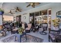 Relaxing covered patio with comfortable seating, ceiling fans, and views of the outdoors at 8780 Bridgeport Bay Cir, Mount Dora, FL 32757
