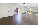 Inviting living room with dark floors, a sliding glass door to the patio, and a mirrored wall at 1009 Royal Oak Blvd, Leesburg, FL 34748