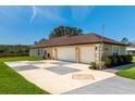 Home's exterior featuring a three car garage with a decorative driveway at 10846 Point Nellie Dr, Clermont, FL 34711